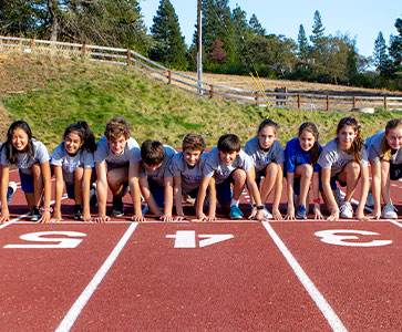 Students racing on the track field. Links to Beneficiary Designations